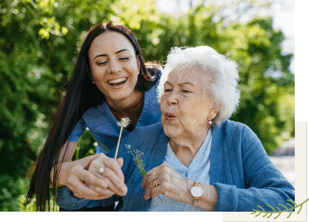 Senior Woman and Woman Blowing out Dandelion